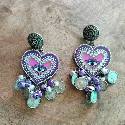 Heart-shaped earrings with decorative elements on a wooden surface