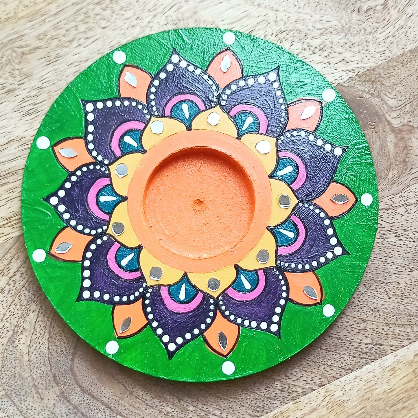Decorative tealight holder with mandala design on a wooden surface