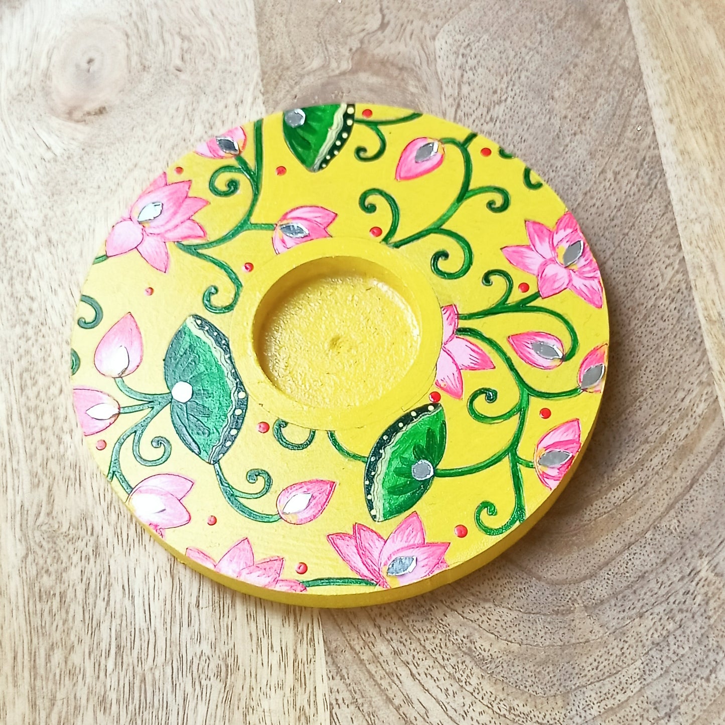 Decorative yellow plate with floral patterns on a stone surface